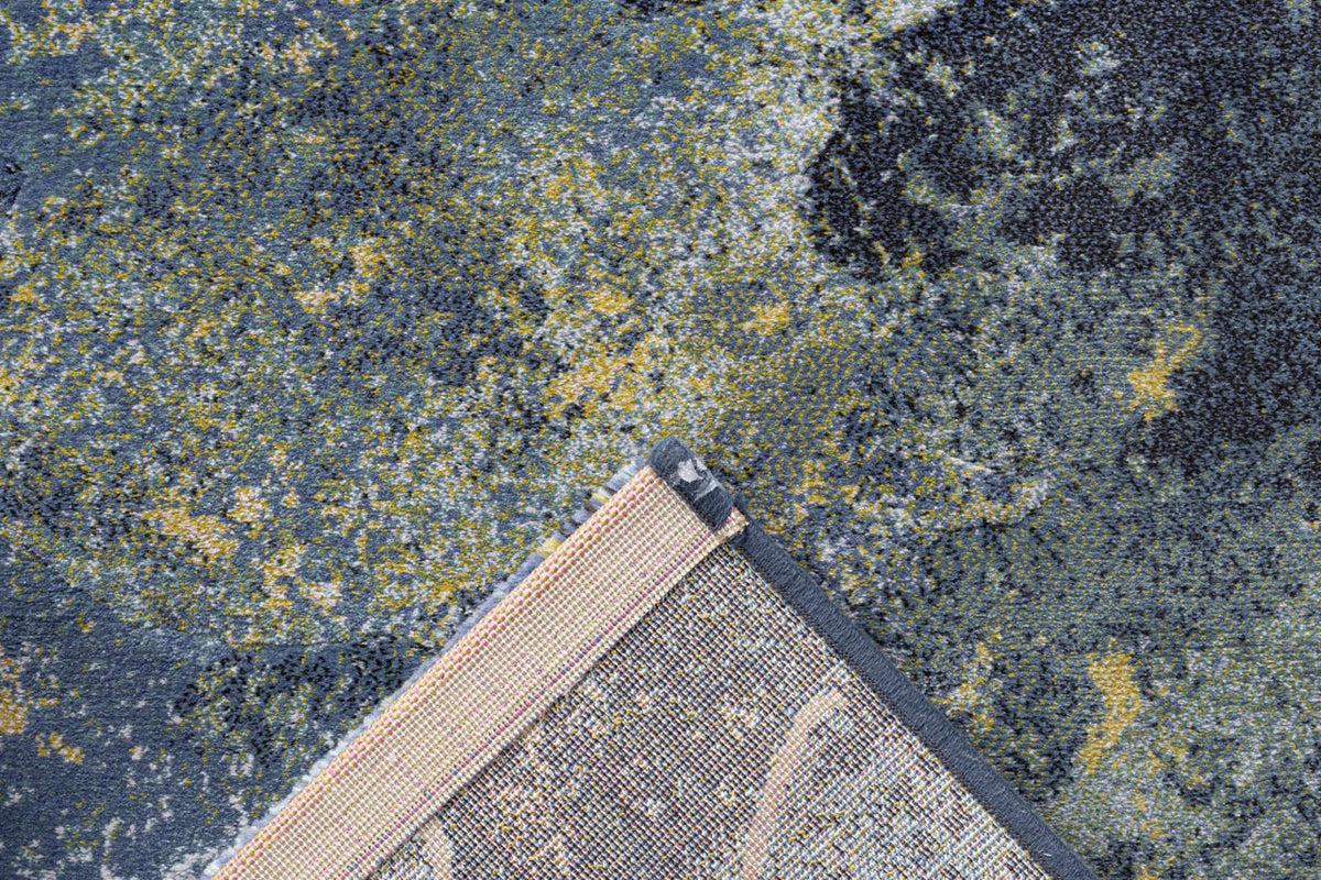 Omgeslagen hoek met de geweven rugzijde van het blauwe Tapison Home Torino 063.0934.5241 vloerkleed