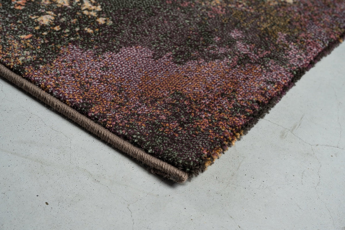 Detail van de hoek van het Tapison Home Torino 063.0934.7274 vloerkleed in pruim, mauve en olijfgroen