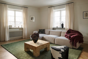 Layered Solid Wool Capulet Olive groen vloerkleed, in een woonkamer