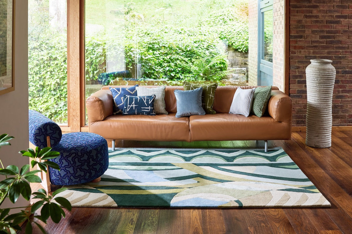 Harlequin Atelier Lagoon vloerkleed in flessengroen, zeegroen en hemelsblauw, in een interieur
