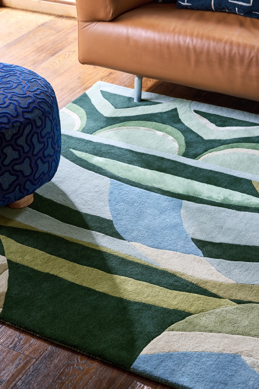 Harlequin Atelier Lagoon vloerkleed in flessengroen, zeegroen en hemelsblauw, in een interieur, tweede beeld