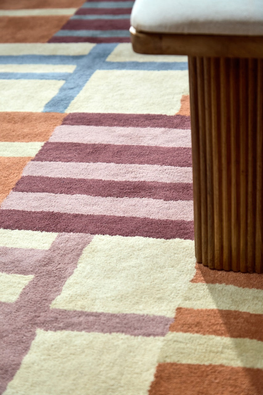 Harlequin Monolith Cinnabar Amber vloerkleed in gebrand oranje, wijnrood en jeansblauw, in een interieur, derde beeld
